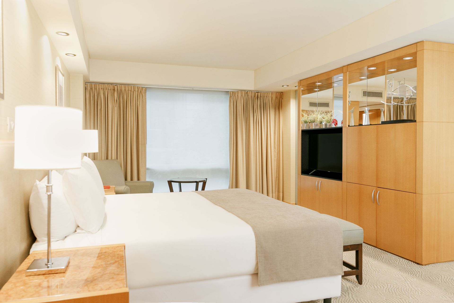 Una habitación de hotel con una cama tamaño king y un televisor.