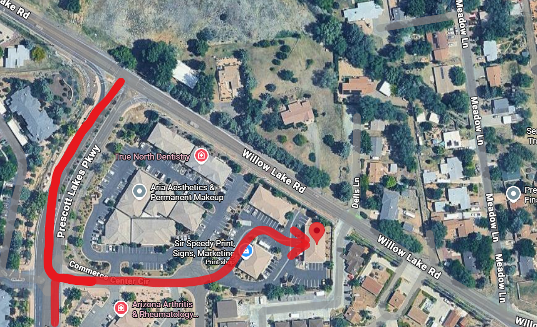 Aerial view of buildings, street, and a railway. A red path indicates a suggested route.