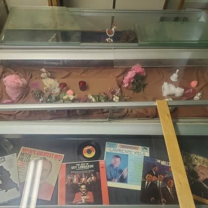 A display case filled with various items including a record and a magazine