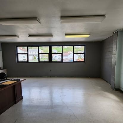 An empty room with a desk and a lot of windows.