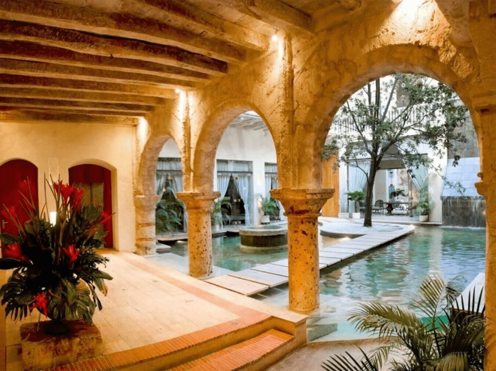 Un edificio con arcos y una piscina en el medio.