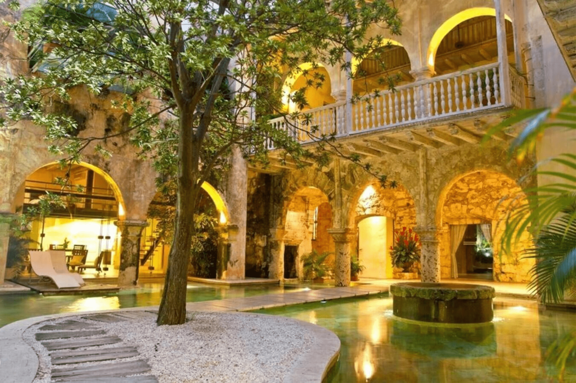 Un gran edificio con arcos y una piscina en el medio.