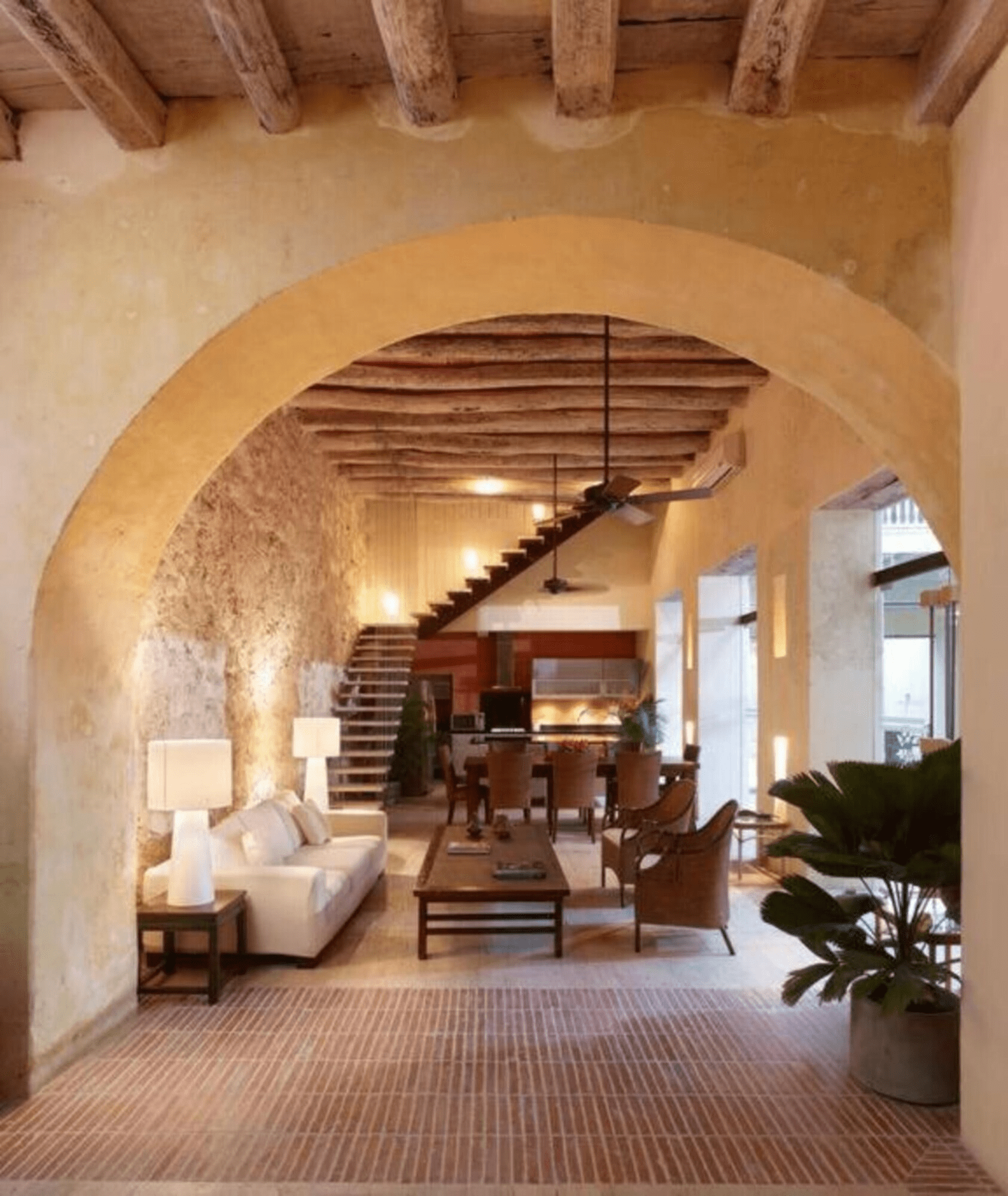 Una sala de estar con una escalera que conduce al comedor.