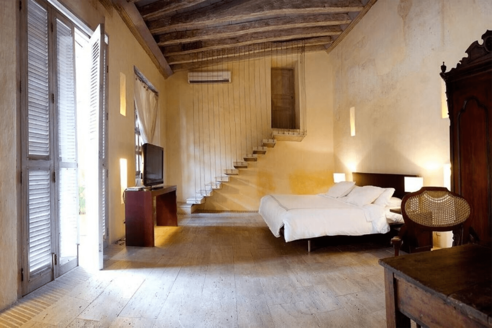 Un dormitorio con una escalera que conduce al segundo piso.