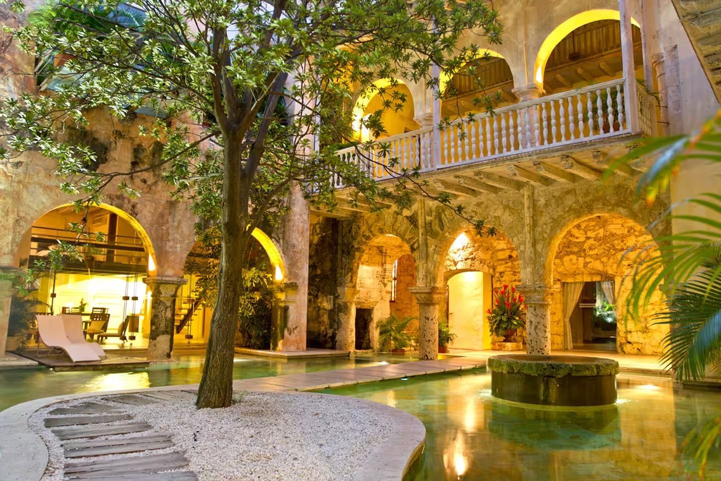 Un gran edificio con arcos y una piscina en el medio.