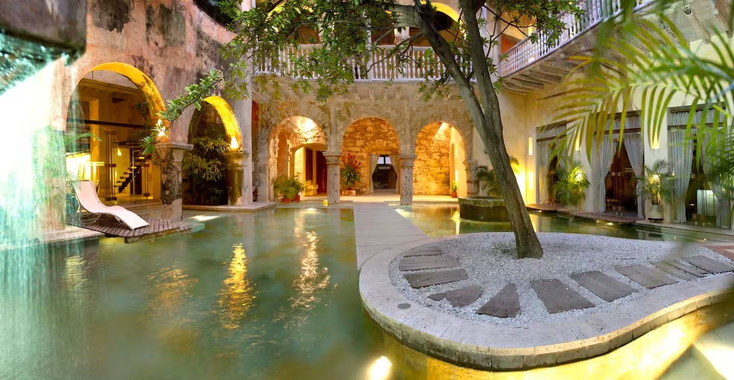 Hay una gran piscina en el medio del patio de un edificio.