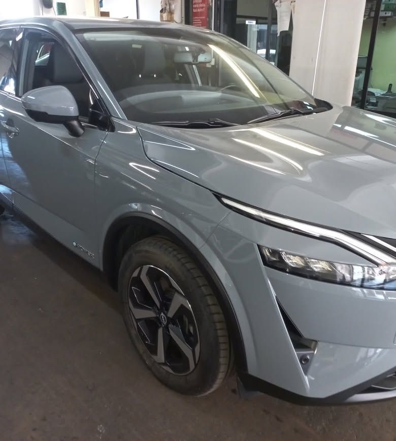 SUV grigio parcheggiato all'interno di uno showroom, visto dalla parte anteriore sinistra.