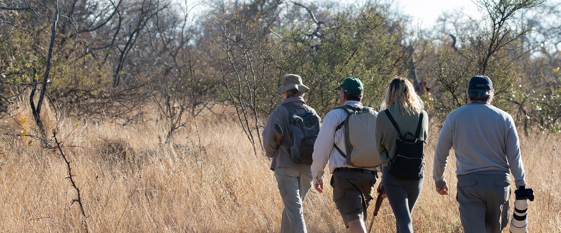A group of people are walking through a field.