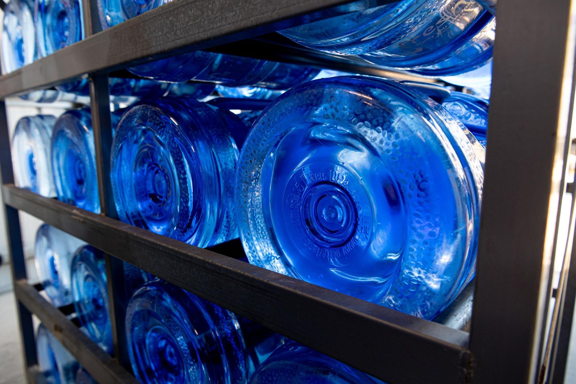 Rows of Blue Water Cooler Jugs Stacked on Metal Shelves — So Fresh Wide Bay in Thabeban, QLD