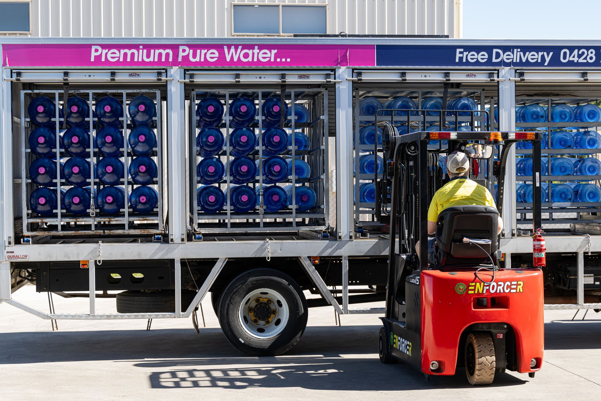 Factory worker monitoring blue bottles on an automated bottling line — So Fresh Wide Bay in Moore Park, NSW