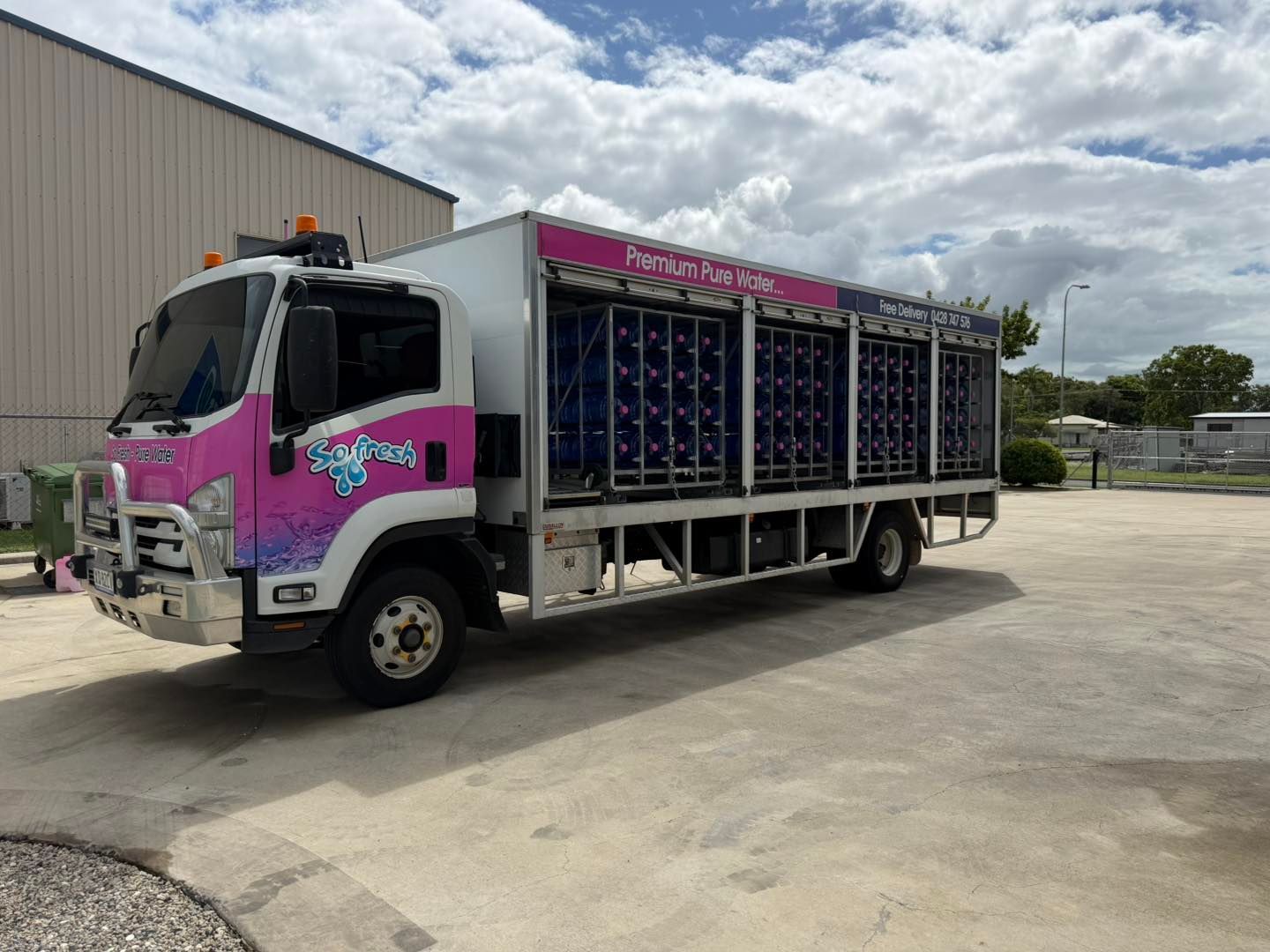 Pink and Silver Cargo Truck Loaded With Stacked Crates Parked Beside a Warehouse — So Fresh Wide Bay in Thabeban, QLD