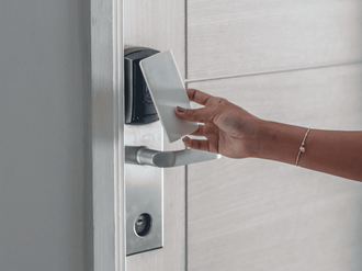 A person is using a credit card to open a door.