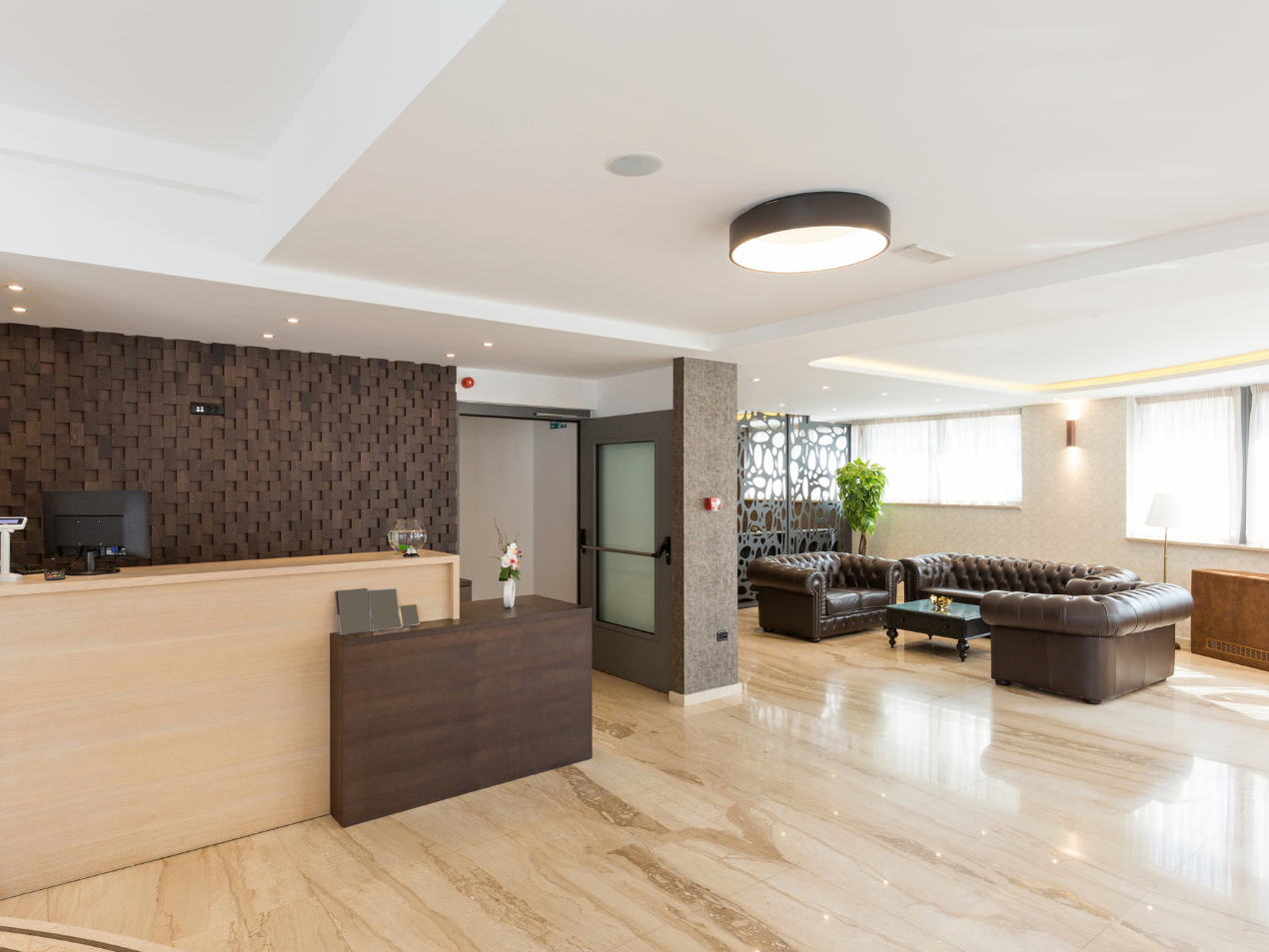 A hotel lobby with a reception desk and a couch.