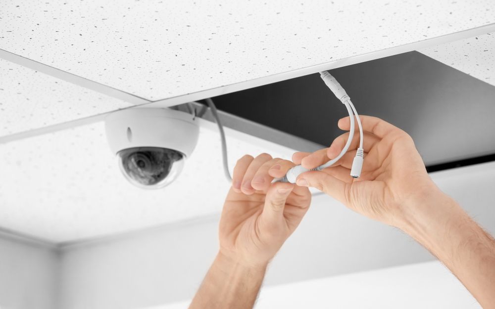 A Person is Installing a Security Camera on the Ceiling — Advantage Communications & Electrical in Maroochydore, QLD
