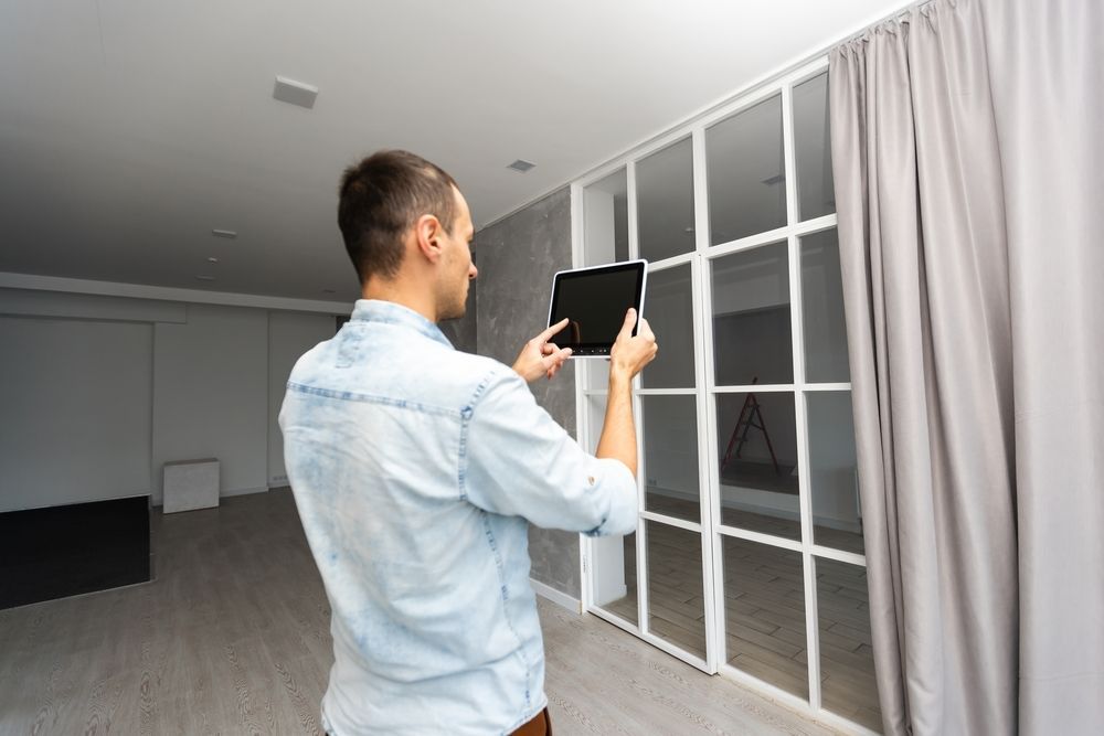 A Man is Looking at a Tablet in an Empty Room — Advantage Communications & Electrical in Maroochydore, QLD