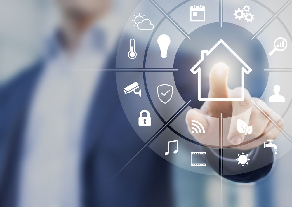 A Man is Pressing a Button With a House Icon on It — Advantage Communications & Electrical in Noosa, QLD