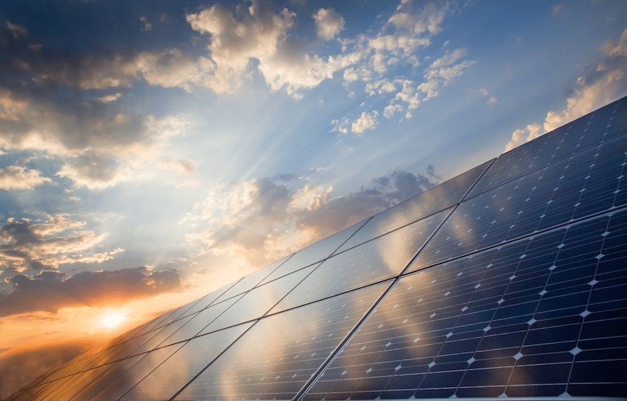 A Row of Solar Panels Against a Cloudy Sky at Sunset — Advantage Communications & Electrical in Noosa, QLD