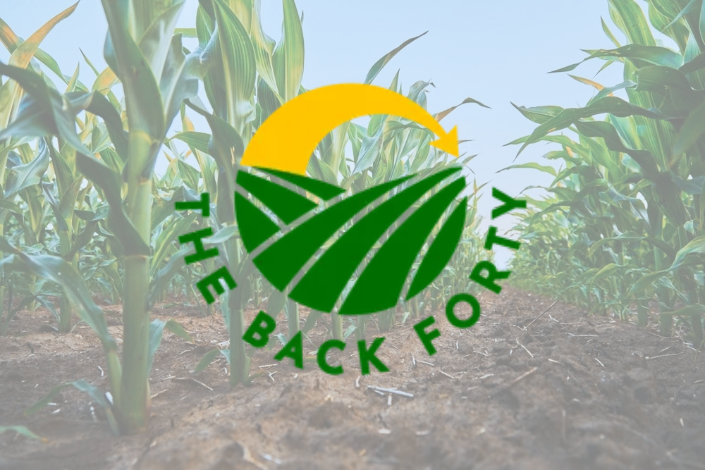 The Back Forty logo over a cornfield with a green leaf and yellow sun design