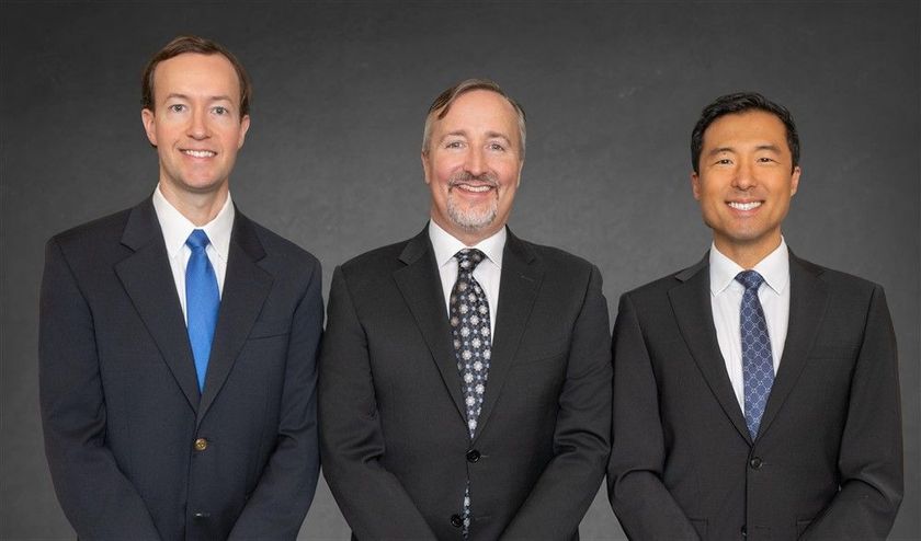 A group of people in suits and ties are posing for a picture in front of a house.