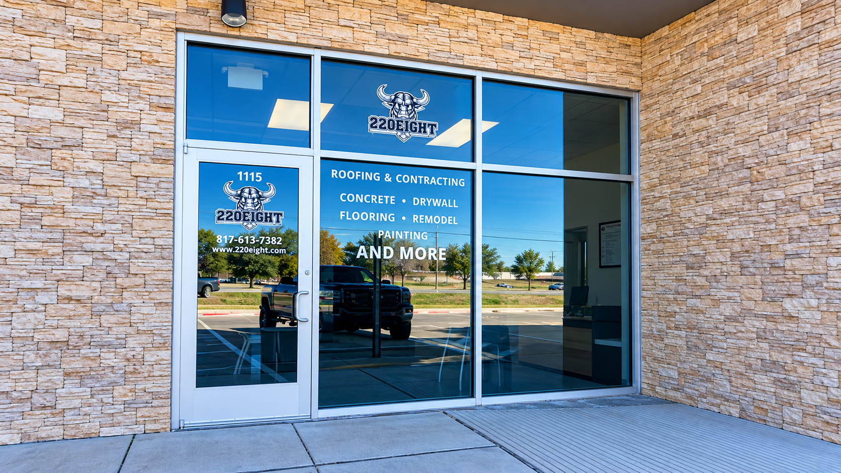 Storefront with glass doors and windows, blue signage, and stone exterior at a shopping center.