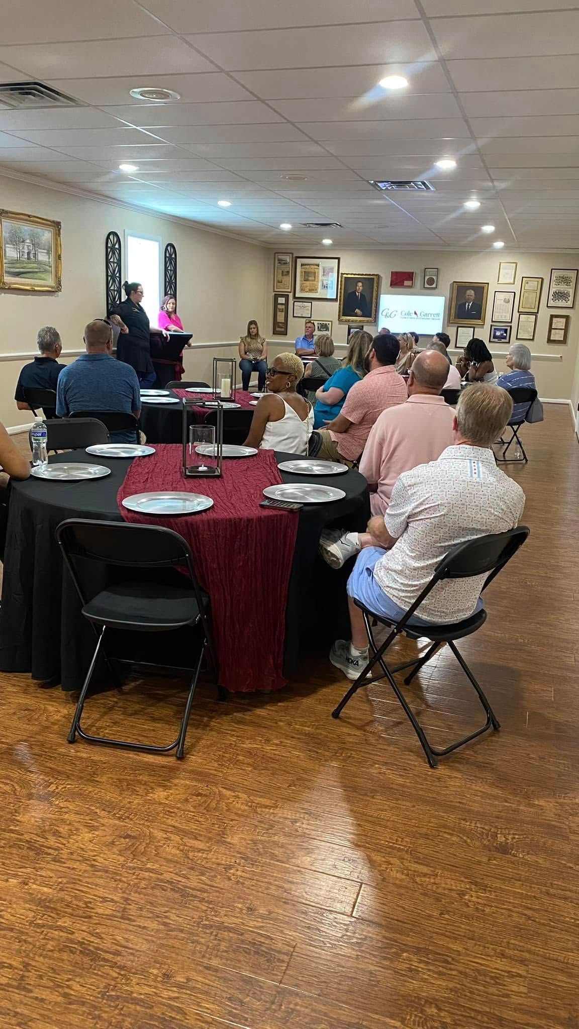 A group of people are sitting at tables in a room.