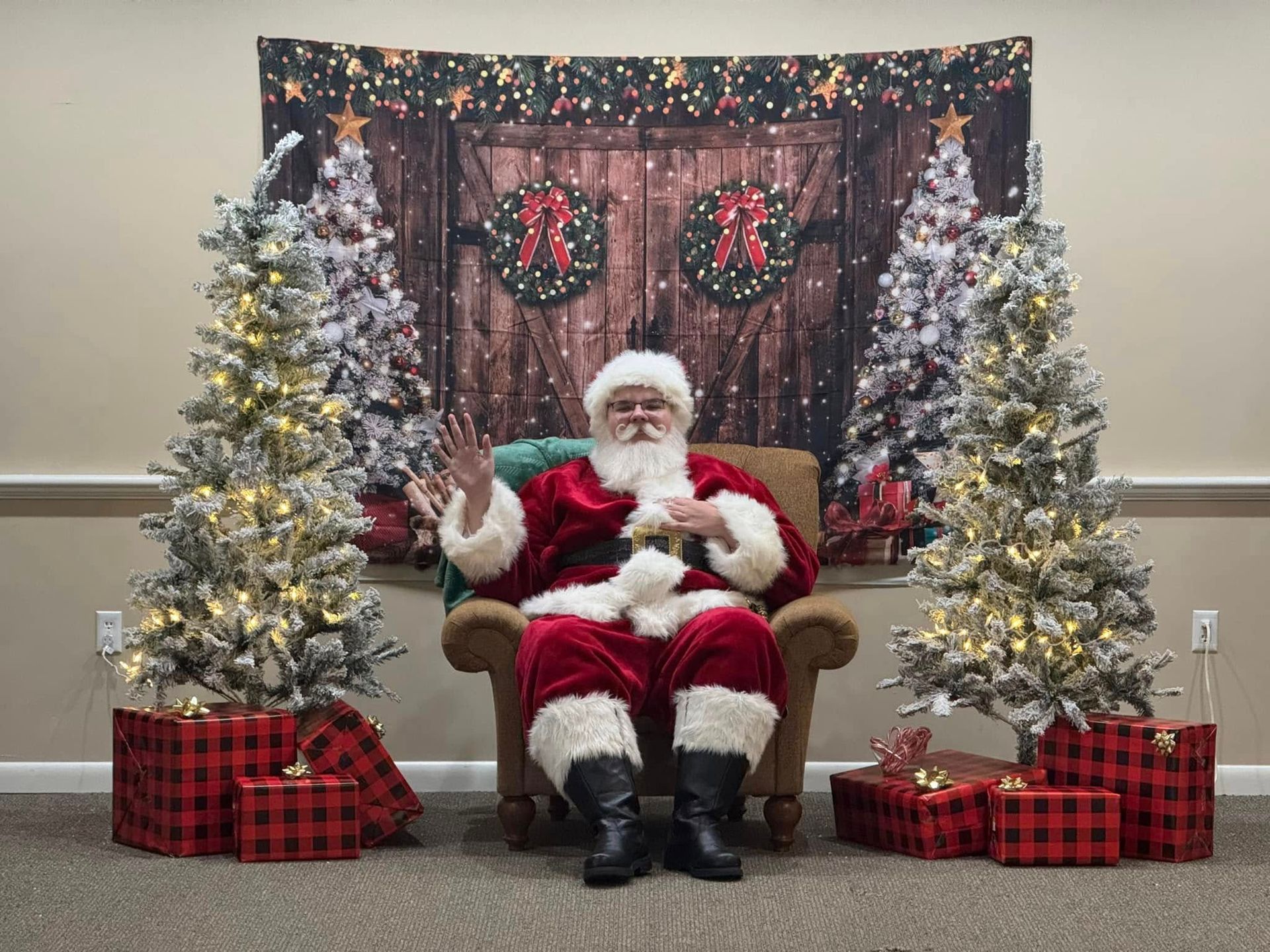 Santa claus is sitting in a chair in front of a christmas tree.