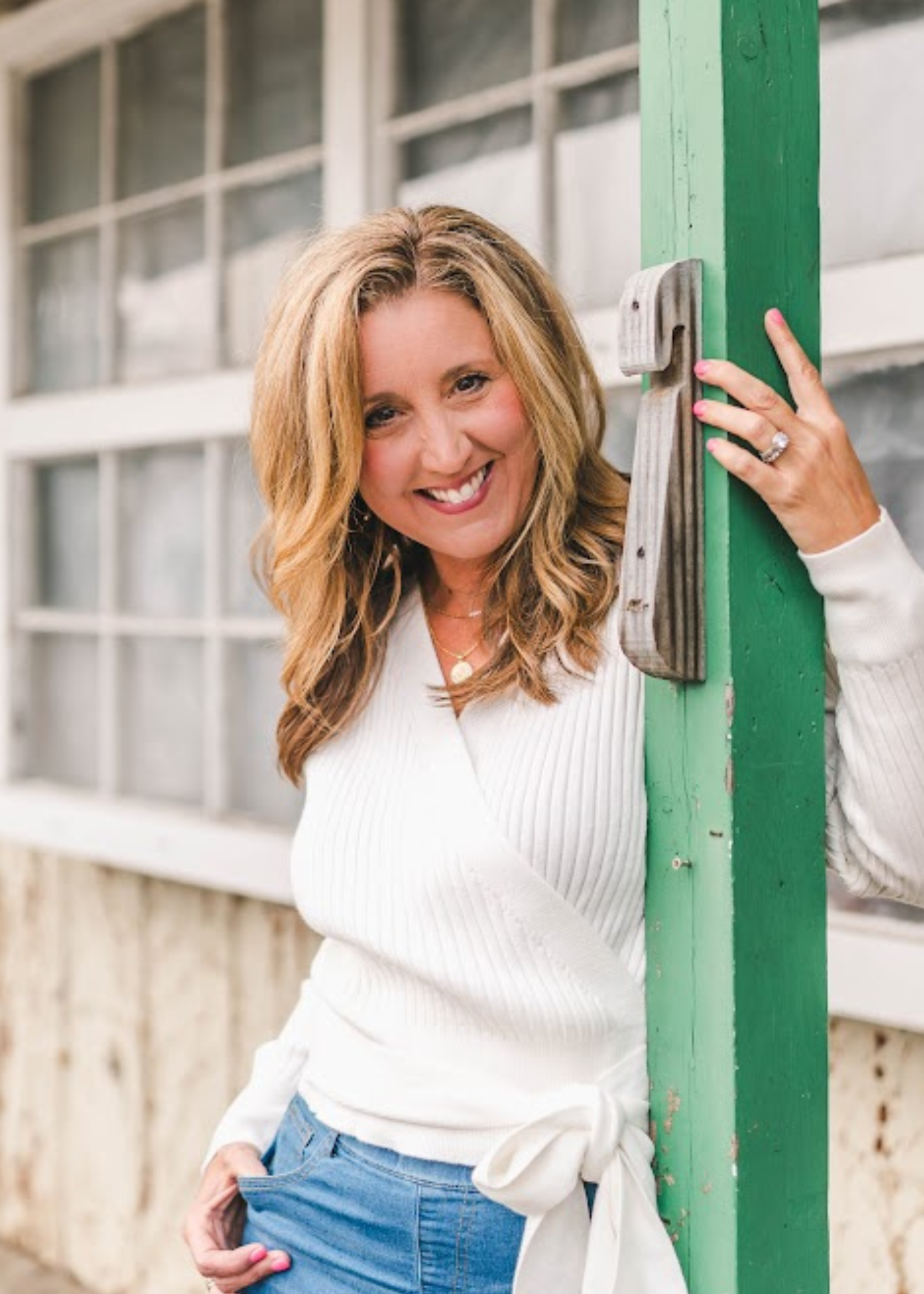 woman in branding session on porch of small business building.