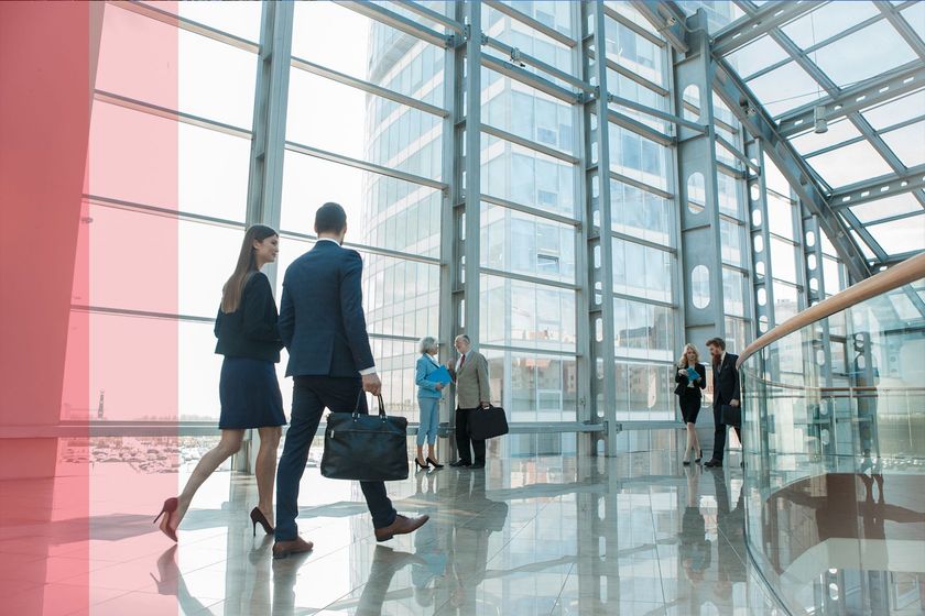 A group of business people are walking through an office building.