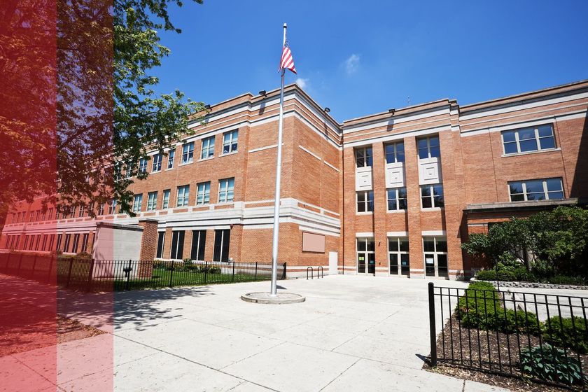 A large brick building with a flag pole in front of it