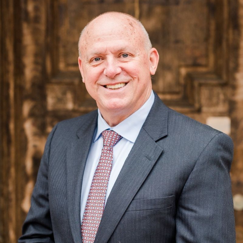 A man in a suit and tie is smiling for the camera.