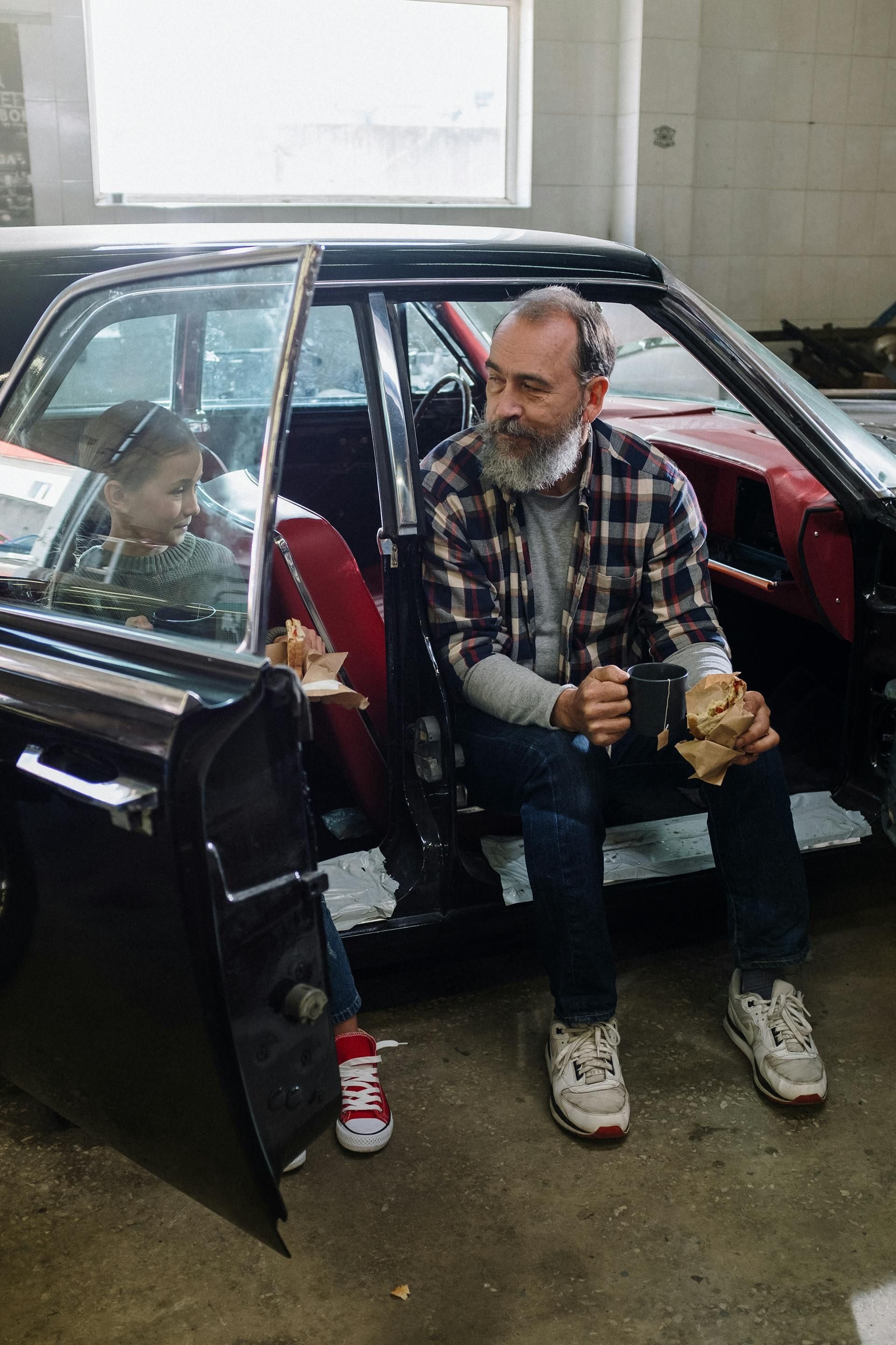 A man and a little girl are sitting in a car.
