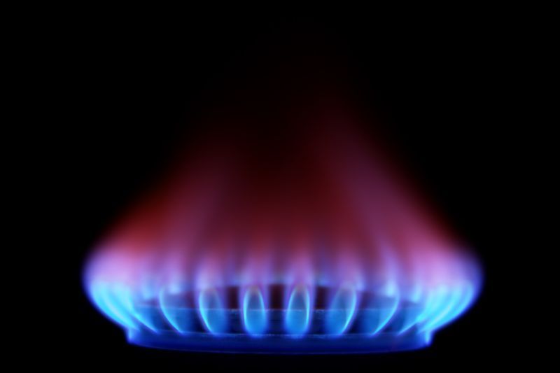 Fiamma di gas blu e rossa che brucia su sfondo nero