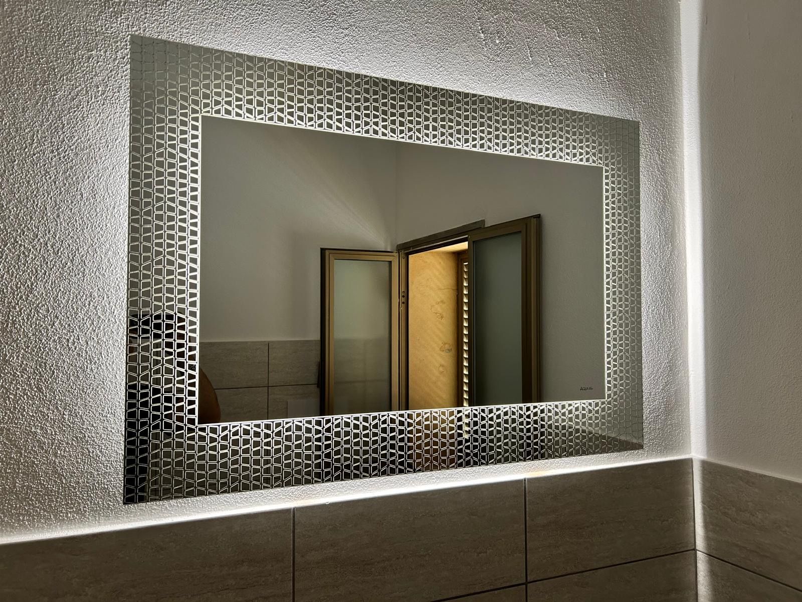 Specchio decorativo da parete che riflette porte di legno aperte in una stanza illuminata da una luce soffusa.