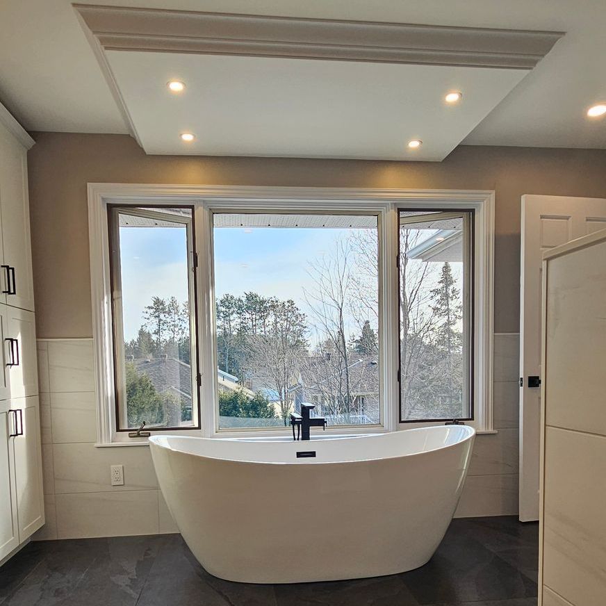 A bathroom with a large tub and a window