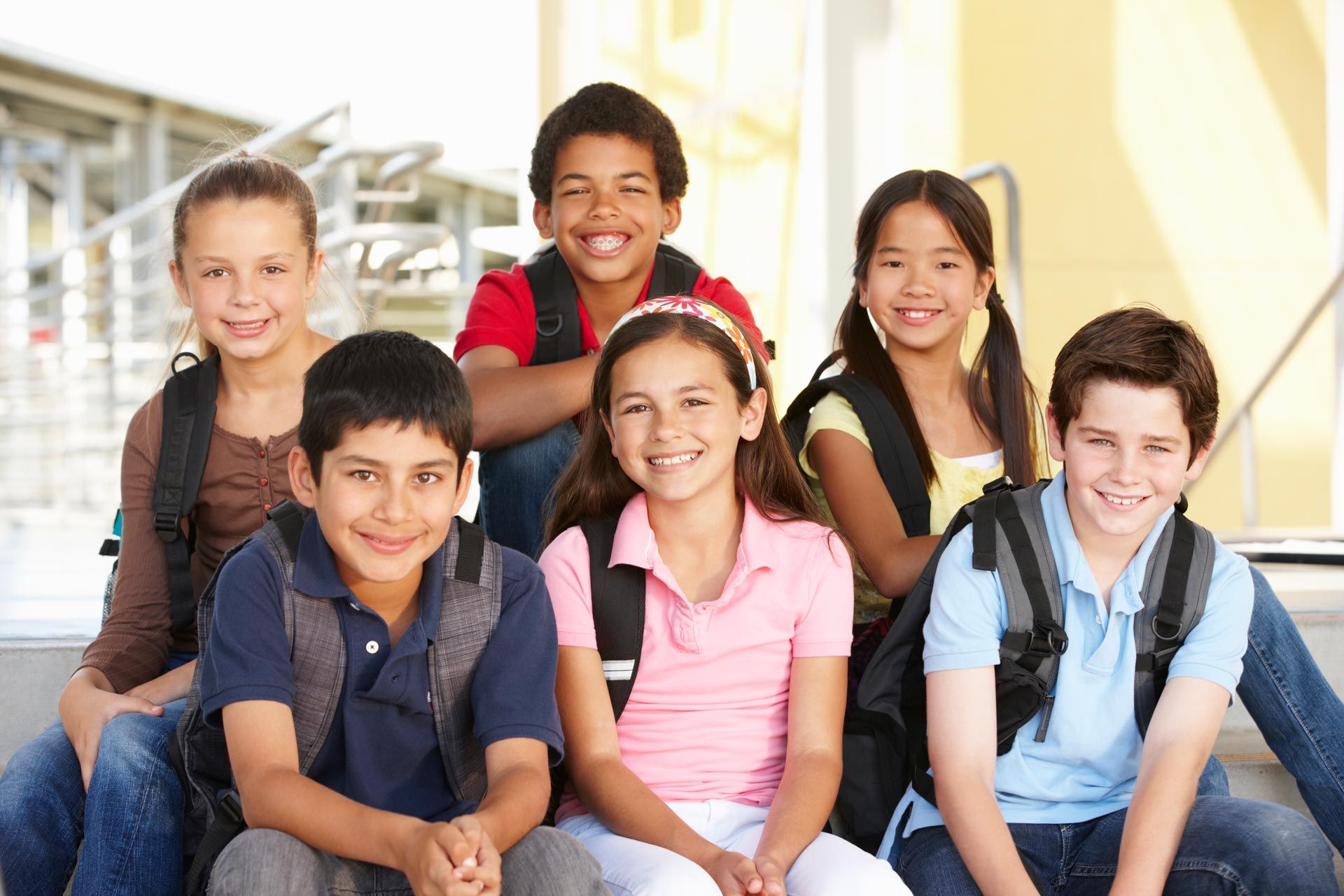 a group of children with backpacks are posing for a picture