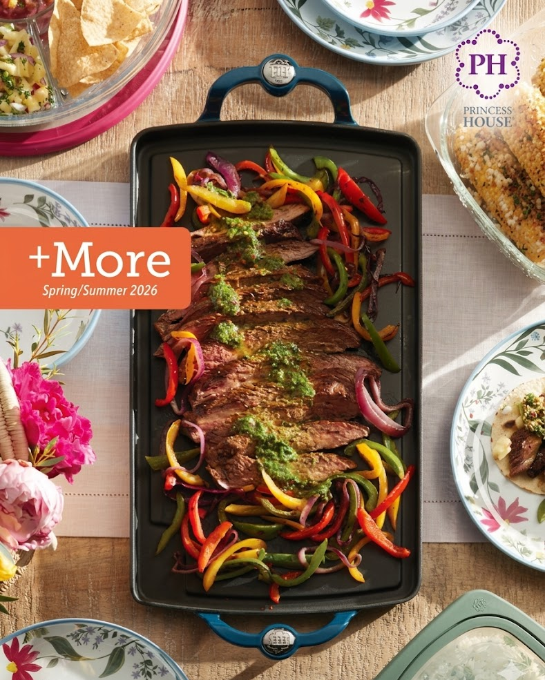 Top-down table with a roasted vegetable platter, floral decor, and side dishes on a rustic spread