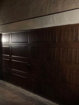 Dimly lit closed garage door with dark wooden panels at night