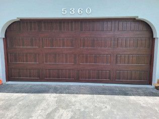 Closed brown garage door with house number 5360 above it