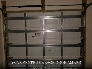 White segmented Amarr garage door with black horizontal braces and small windows on top.