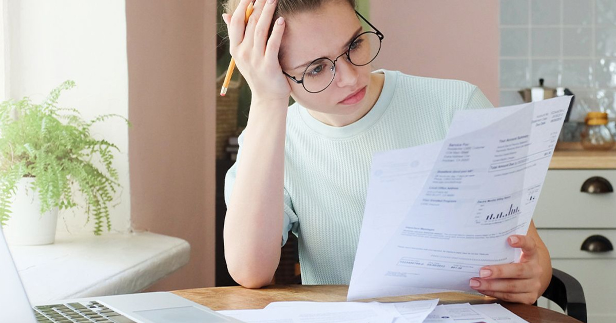 A young woman reading finance documents.