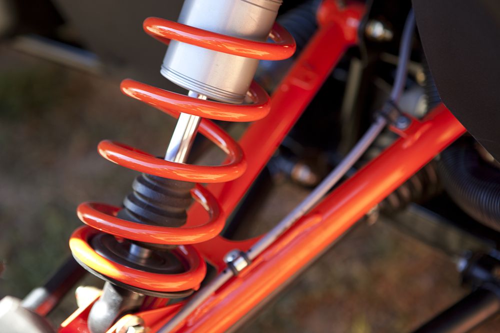 Red Coil Spring Shock Absorber on a Red Vehicle Frame — GA Plant & Automotive Repairs In Armidale, NSW