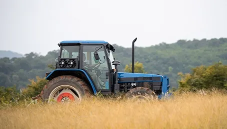 A Blue Tractor is Plowing a Field — GA Plant & Automotive Repairs In Narrabri, NSW