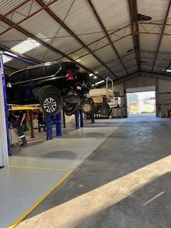 A Black 4WD on a Hoist in a Workshop  — GA Plant & Automotive Repairs In Armidale, NSW