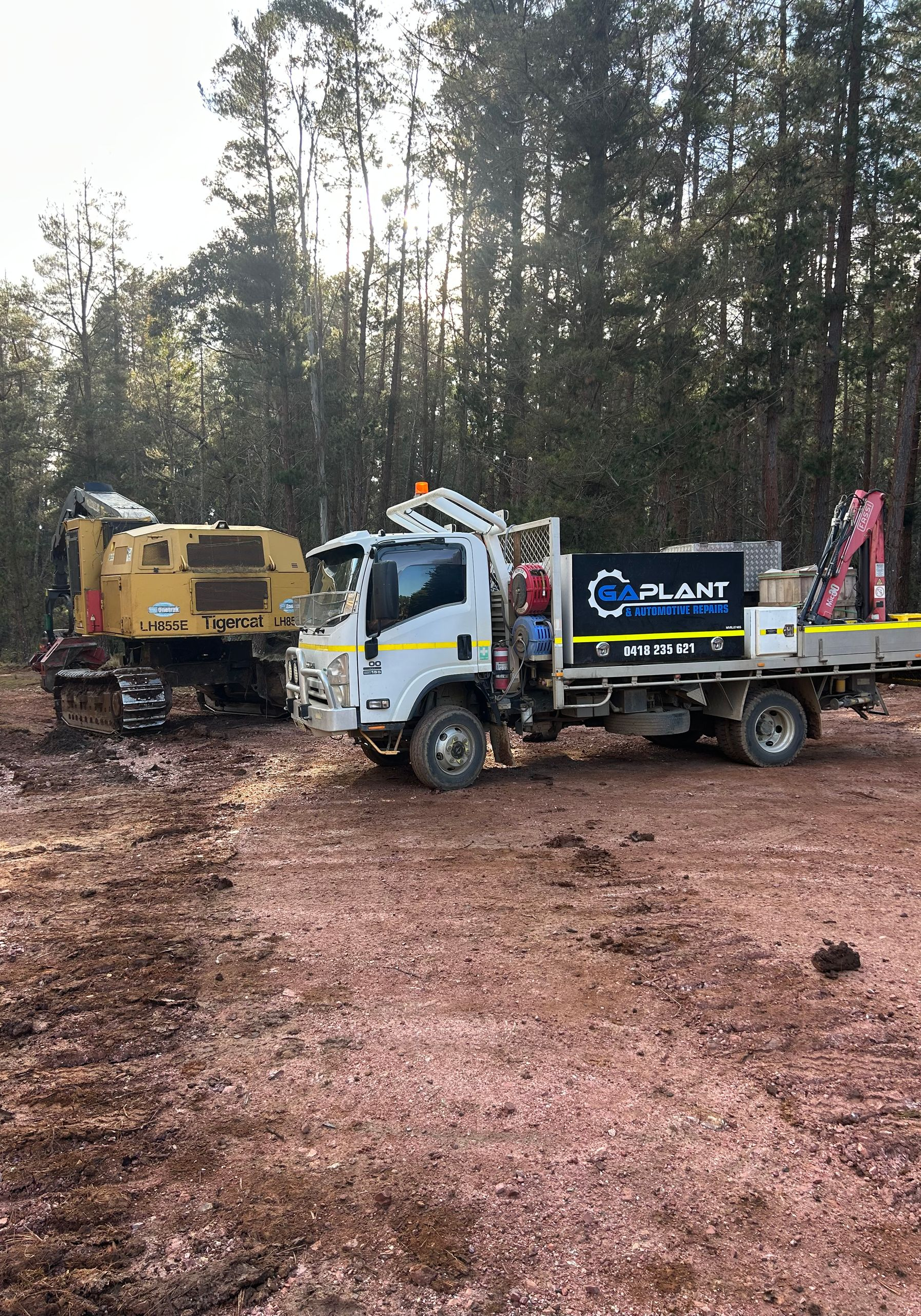 Yellow Bulldozer With Tracks Inside a Barn With Hay Bales — GA Plant & Automotive Repairs In Taminda, NSW