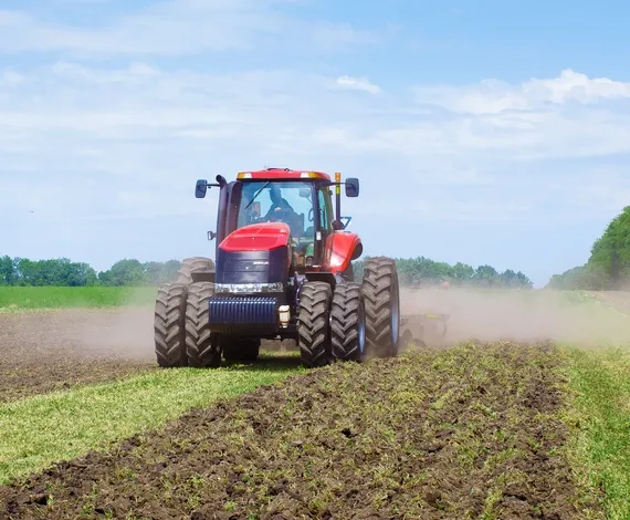 A Red Tractor Plowing a Field — GA Plant & Automotive Repairs In Taminda, NSW