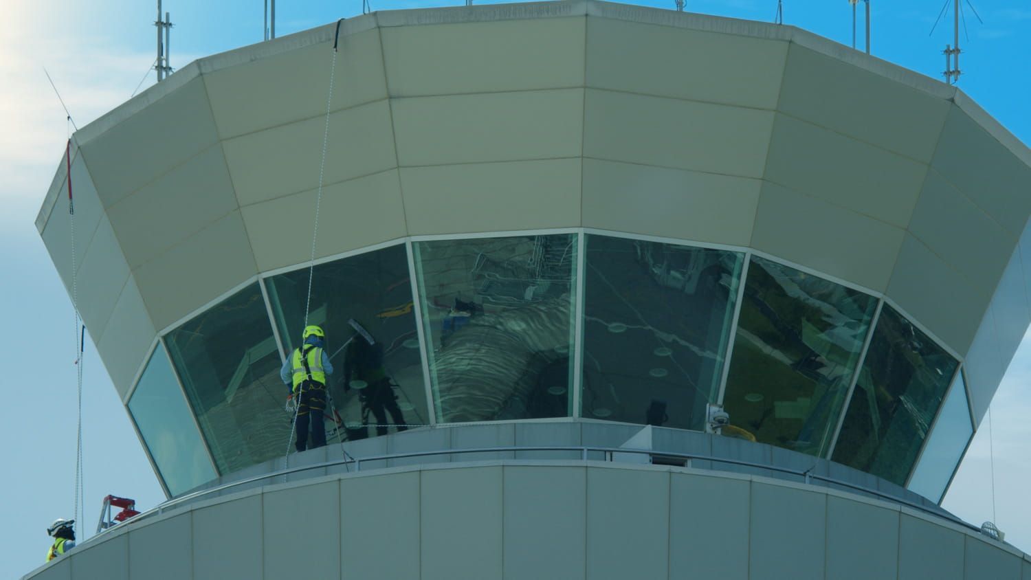 Torre de control de tráfico aéreo con trabajadores visibles detrás del cristal.