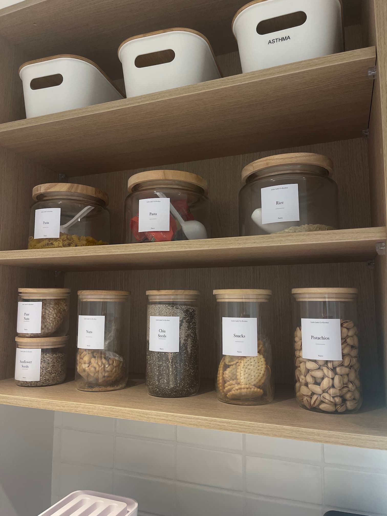 Pantry food organisation containers with labels.