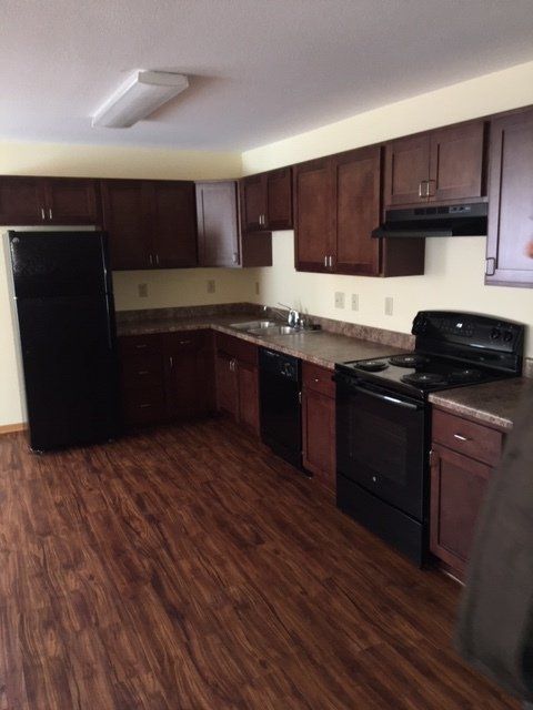 Kitchen with black stove, black refrigerator, and dishwasher.