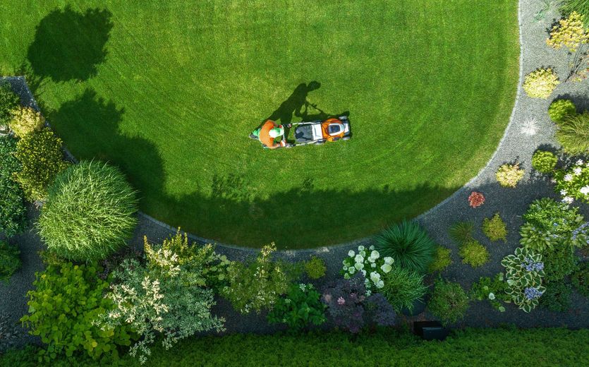 An aerial view of a person laying on top of a lush green lawn.