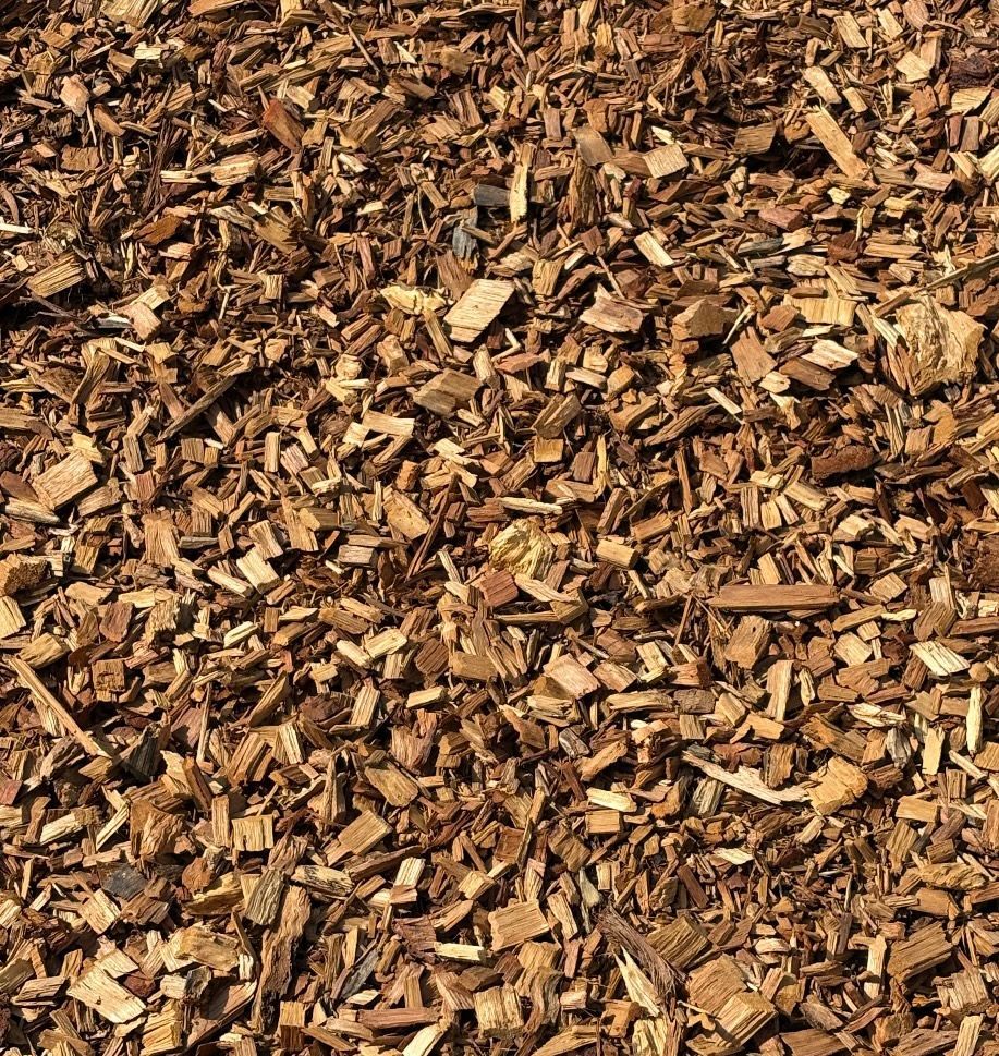 Pile of brown wood chips and bark mulch, filling the frame.